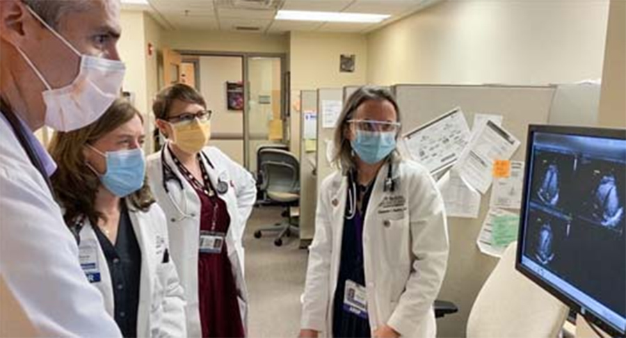 Photo of medical staff wearing masks reviewing a patient’s imaging.